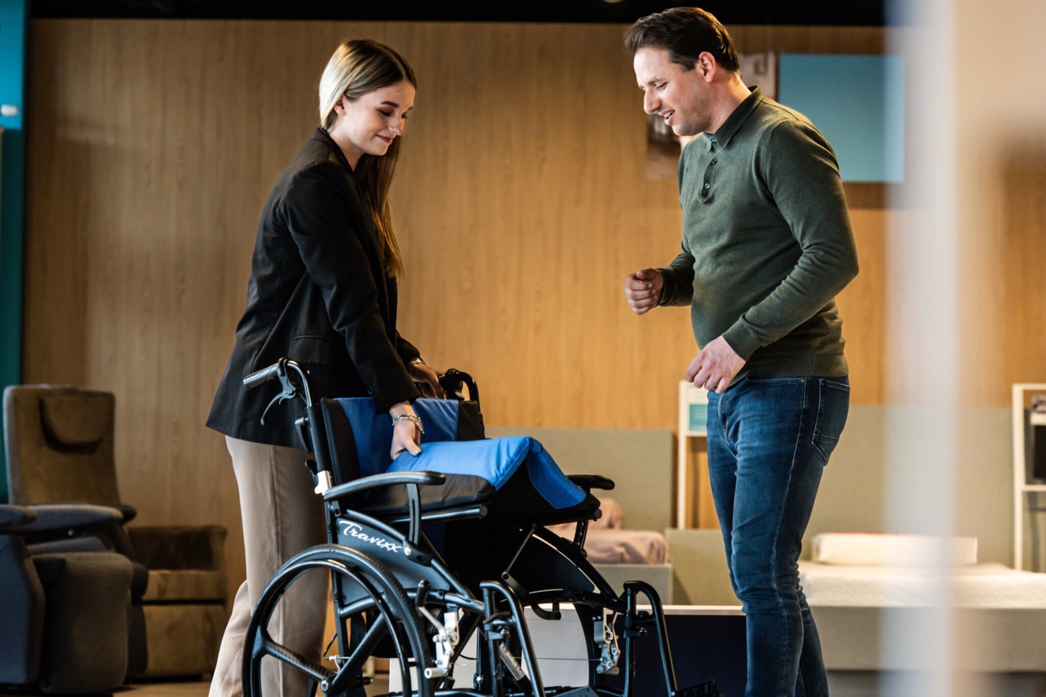 Foto van vrouw die een rolstoel inklapt terwijl een man toekijkt